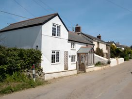 A house with white walls and a gate at The Cottage in Helston