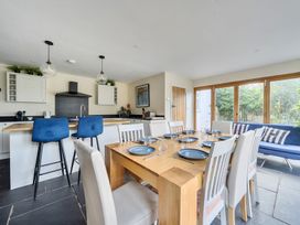 A dining room with a kitchen island and dining table at The Cottage in Helston