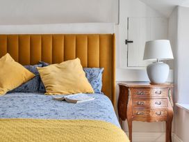 A bedroom with a bed and a nightstand at The Cottage in Helston
