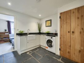 A utility room with a washing machine and a sink at The Cottage in Helston