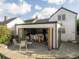 An outdoor patio with a dining table and chairs at The Cottage in Helston