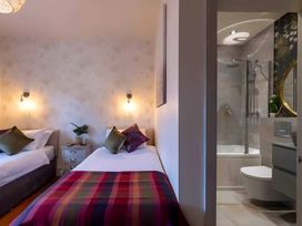 A bedroom with two beds and an adjoining bathroom at 29 Chapel Street Appleby-In-Westmorland