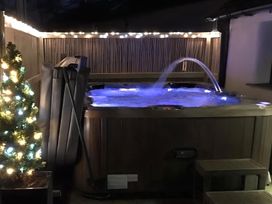 An outdoor space featuring a hot tub and decorative lighting at Granary Barn in Winkleigh
