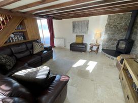 A living room with a sofa and a stove at Granary Barn in Winkleigh