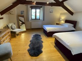 A bedroom with two beds and a mirror at Granary Barn in Winkleigh