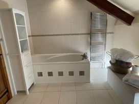 A bathroom with a bathtub and towel warmer at Granary Barn in Winkleigh