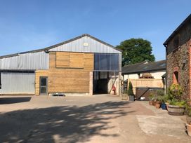 An outdoor area with a large barn and surrounding features at Granary Barn in Winkleigh