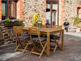 A dining area with table and chairs at Granary Barn in Winkleigh
