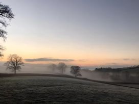 A landscape with fog and trees at Granary Barn in Winkleigh