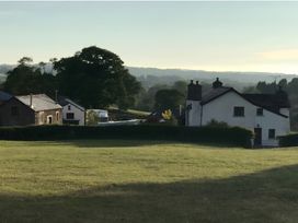 Houses with trees and grass in the countryside at Granary Barn in Winkleigh