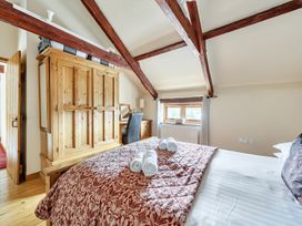 A bedroom with a bed and wardrobe at Granary Barn in Winkleigh