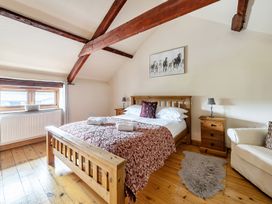 A bedroom with a wooden bed and bedside tables at Granary Barn in Winkleigh