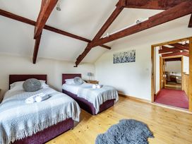 A bedroom with twin beds and a painting at Granary Barn Winkleigh