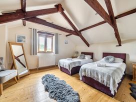 A bedroom with two beds and a mirror at Granary Barn in Winkleigh