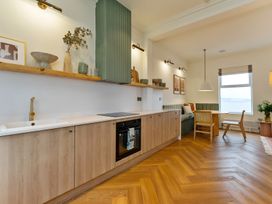 A kitchen with cabinets and a dining area at Seafront Apartment in Donaghadee