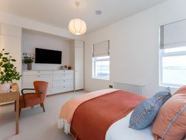 A bedroom with a bed and television at Seafront Apartment in Donaghadee