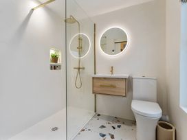 A bathroom with a shower, toilet, and vanity at Seafront Apartment in Donaghadee