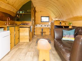 A living room with a kitchen area and a sofa at Glamping pod-Luxury Glamping Retreat in Battle