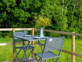 A table with chairs and flowers on a patio at Glamping pod-Luxury Glamping Retreat, Battle