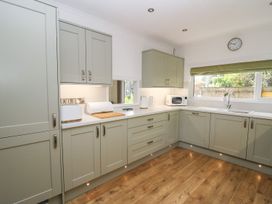 A kitchen with cabinets, sink, and appliances at Tymelyn Aberystwyth