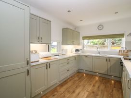 A kitchen with cabinets and a microwave at Tymelyn in Aberystwyth