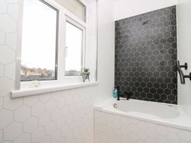A bathroom with a bathtub and window at Tymelyn in Aberystwyth