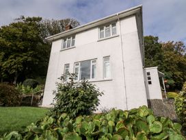 A house with windows and plants surrounding it at Tymelyn in Aberystwyth