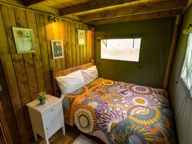 A bedroom with a bed and bedside table at Badger - Luxury Glamping Retreat in Battle
