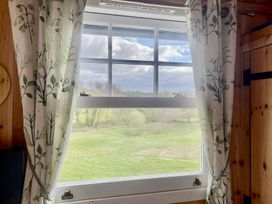 A window view with curtains overlooking greenery at Tylands in Camelford
