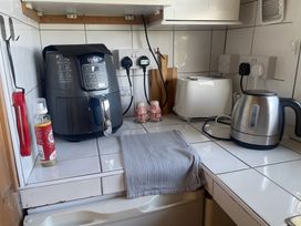 A kitchen with an air fryer, toaster, kettle, and cleaning spray at Tylands in Camelford