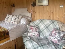 A bedroom with a bed and sofa at Tylands in Camelford