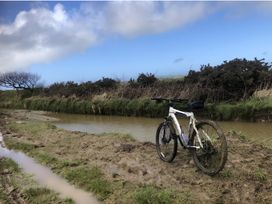 A mountain bike near a muddy path and water at Tylands in Camelford