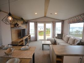 A living room with a sofa and dining table at 601 Cribbar Cove in Perranporth