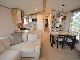 A living room and kitchen area with sofa and dining table at 601 Cribbar Cove Perranporth