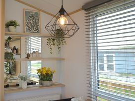 A dining room with a lamp and plants at 601 Cribbar Cove Perranporth