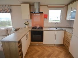 A kitchen with gas stove, sink, and cabinets at 601 Cribbar Cove, Perranporth