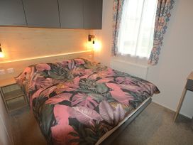 A bedroom with a bed and bedside table at 601 Cribbar Cove in Perranporth