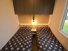 A bedroom with two beds and a nightstand at 601 Cribbar Cove Perranporth