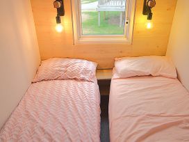 A bedroom with two beds and a window at 601 Cribbar Cove Perranporth