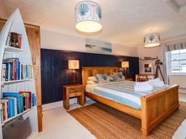 A bedroom with a bed and bookshelf at Cubbs Corner in Goonbell near St Agnes