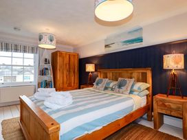 A bedroom with a bed and wardrobe at Cubbs Corner in Goonbell near St Agnes