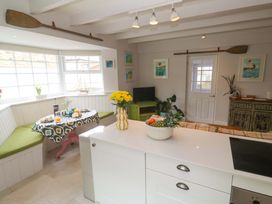 A kitchen with a table and benches at Cubs Corner in St Agnes