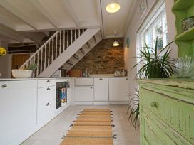 A kitchen with a staircase and green cabinet at Cubs Corner in St Agnes