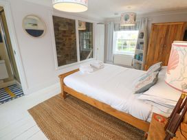 A bedroom with a bed and bookshelf at Cubs Corner in St Agnes