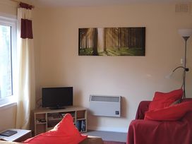 A living room with a sofa and television at Satchwell Chalet in Inverness