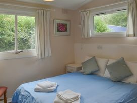 A bedroom with a bed and windows at Satchwell Chalet in Inverness