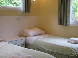 A bedroom with two beds and a window at Satchwell Chalet in Inverness