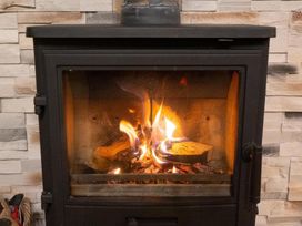 A fireplace with burning logs in the living room at Valley View Lodge 1 Preston
