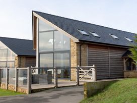 A house with large glass doors and wooden fence at Pendle View Preston