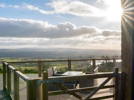 A balcony with a table and chairs overlooking a scenic view at Pendle View in Preston
